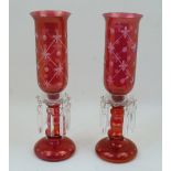 A pair of cranberry glass lustre candlestick lamps, 20th century, with clear glass sconces and