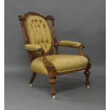 A Victorian walnut armchair, with carved back and armrests, damask button back upholstery, raised on