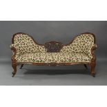 A Victorian mahogany spoon back sofa, the central carved and pierced floral decoration and carved