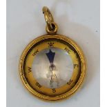 A gold fob compass, late 19th century, stamped 18ct, with suspension loop, 2.6cm diameter, gross