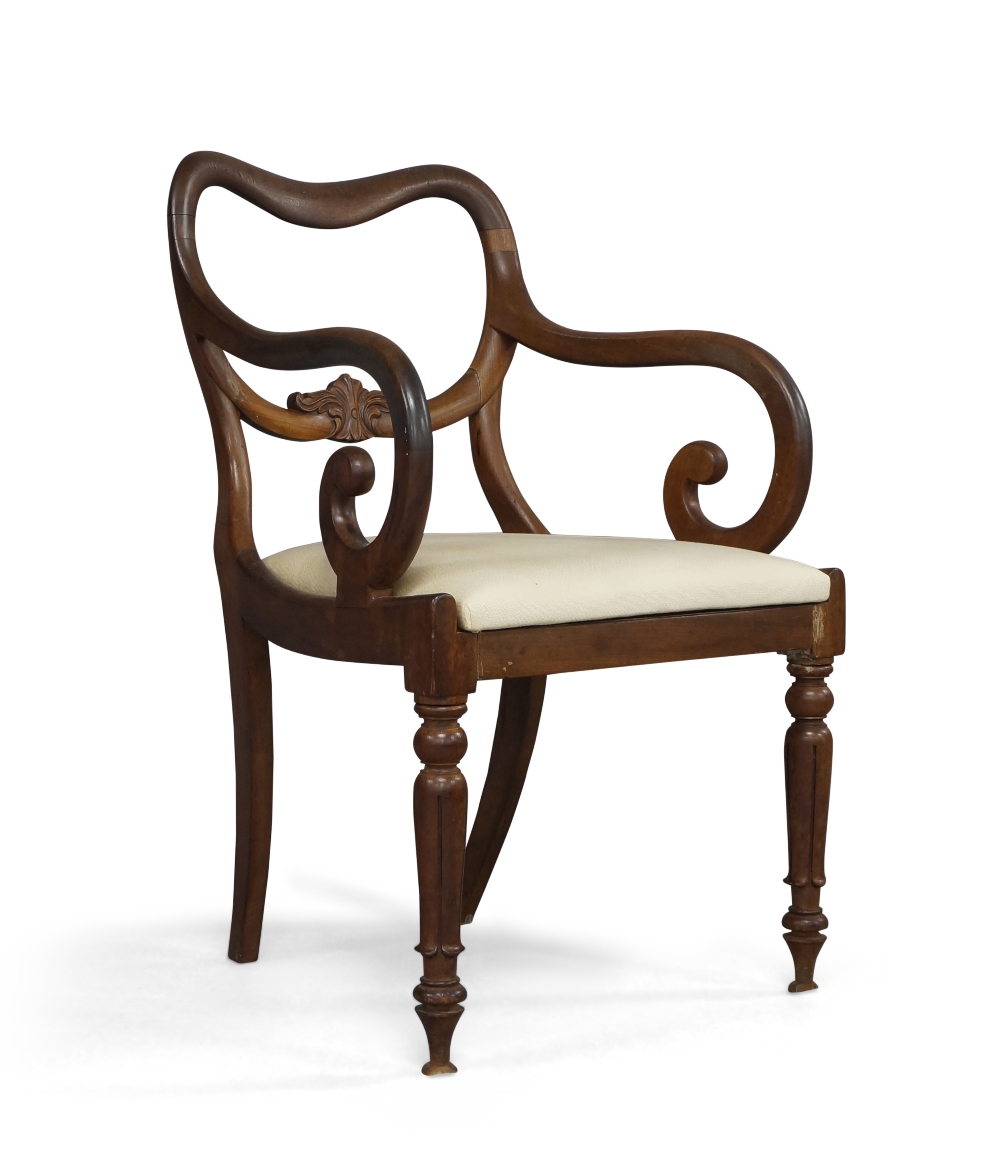 A William IV mahogany open arm elbow chair, with carved floral back rail, above drop in seat, raised