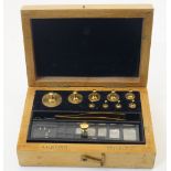 A set of brass jewellers' weights, held in a fitted wood case with a pair of tweezers, the case