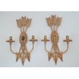 A pair of two light wall appliques, late 20th century, painted resin, in the form of three arrows