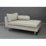 A modern chaise lounge, with grey and cream check fabric, raised on chrome supports, reputedly