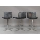 A set of three modern swivel stools, with black leather upholstery, raised on chrome supports (3)