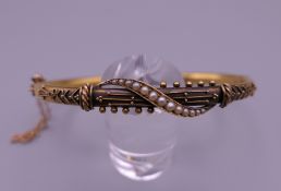 A gold seed pearl bangle form bracelet. 6 cm diameter. 6.7 grammes total weight.