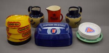 A quantity of pub advertising jugs and ashtrays.