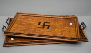A pair of early 20th century oak trays inlaid with Swastika. The largest 71.5 cm wide.