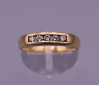 An 18 ct gold diamond five stone ring. Ring size M. 3.6 grammes total weight.
