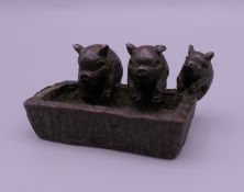 A bronze model of three pigs at a trough. 4.5 cm wide.