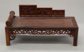 A wooden model of a Chinese day bed.