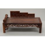 A wooden model of a Chinese day bed.