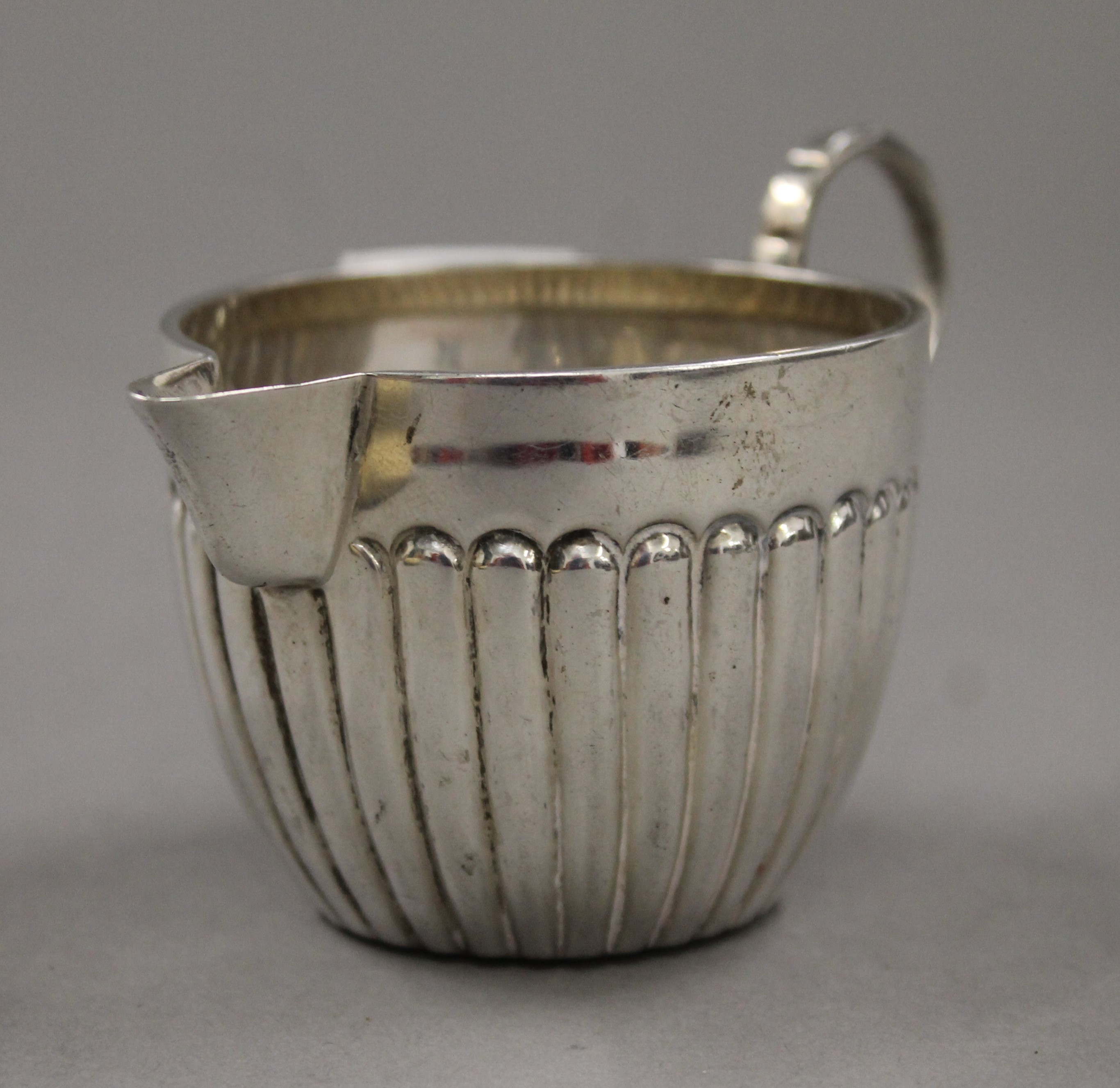 A small silver cream jug (53 grammes) and a silver handled crumb brush. The former 6.5 cm high. - Image 3 of 8