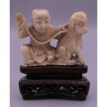A 19th century Chinese carved ivory model of a boy and dog, mounted on a pierced wooden stand. 7.