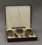 A boxed silver and tortoiseshell dressing table set.