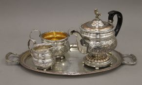 A Victorian three-piece ornate silver plated tea set and a tray.