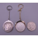 Two 1880 silver dollars each set as a keyring and a 1974 one dollar coin.