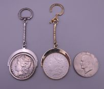 Two 1880 silver dollars each set as a keyring and a 1974 one dollar coin.