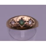 A 9 ct gold diamond and emerald gypsy set ring. 2.4 grammes total weight.