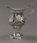 An embossed Georgian silver cream jug. 10.5 cm high. 91.5 grammes.