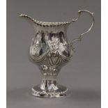 An embossed Georgian silver cream jug. 10.5 cm high. 91.5 grammes.