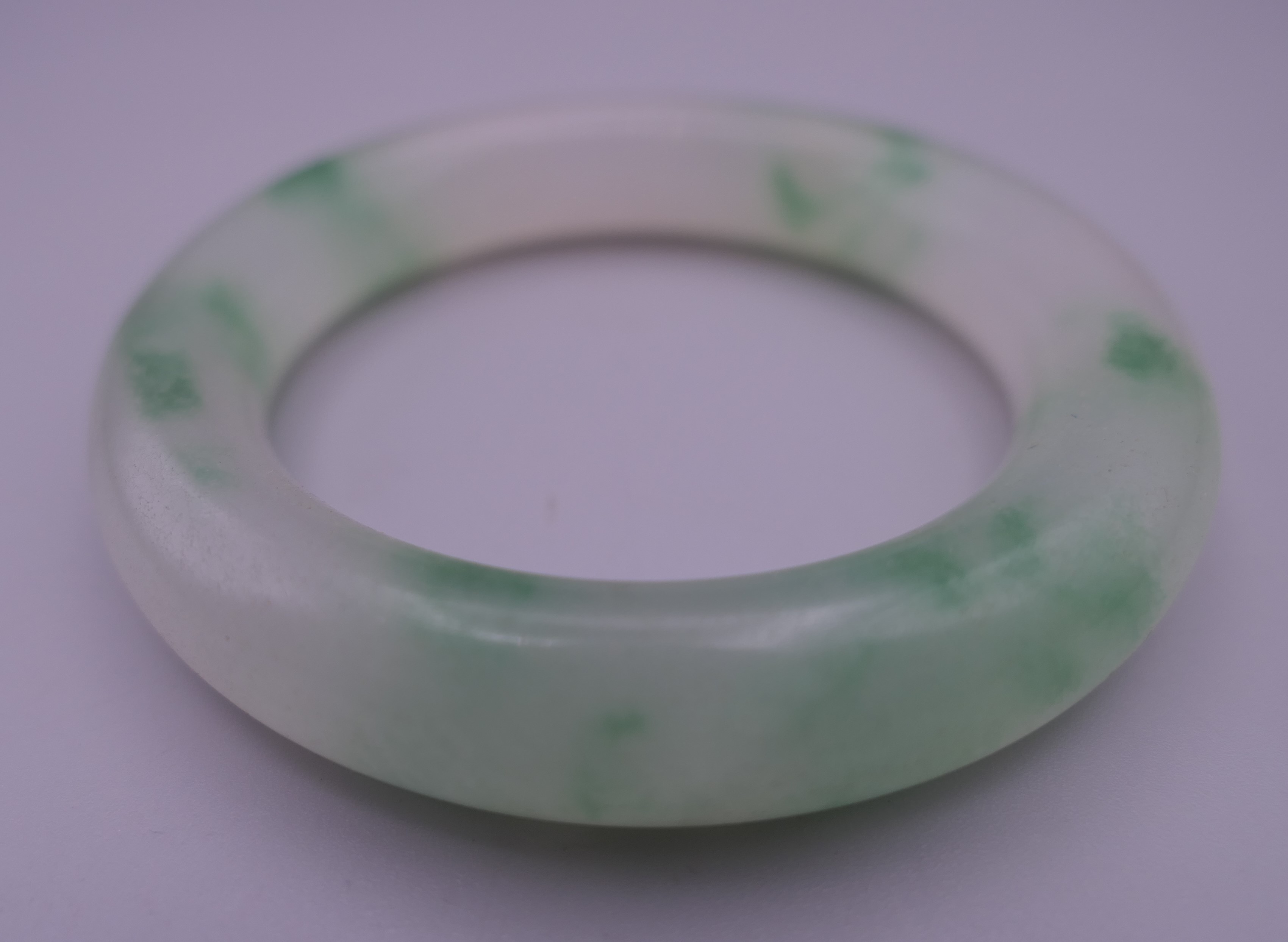 A jade bangle. 7.5 cm exterior diameter, 5.5 cm interior diameter. - Image 2 of 3