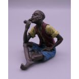 A cold painted bronze model of a boy smoking a pipe. 5.5 cm high.