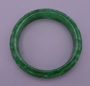 A carved jade bangle. 7.5 cm exterior diameter, 6 cm interior diameter.