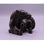 A carved wooden netsuke formed as a horse. 3.5 cm high.