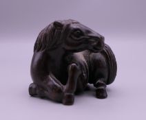 A carved wooden netsuke formed as a horse. 3.5 cm high.