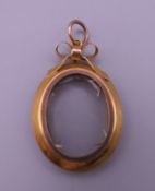 An Edwardian 9 ct gold double sided photo locket. 3.5 cm high. 4.1 grammes total weight.