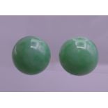 A pair of 9 ct white gold apple green jade cabochon earrings. 1.25 cm diameter.