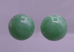 A pair of 9 ct white gold apple green jade cabochon earrings. 1.25 cm diameter.