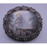 A 19th century unmarked silver filigree brooch set with a miniature painting on ivory. 6.5 cm wide.