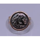 An 18 ct gold ring set with a Roman coin. Ring size E. 2.3 grammes total weight.