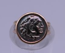 An 18 ct gold ring set with a Roman coin. Ring size E. 2.3 grammes total weight.