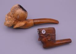 A 19th century Meerschaum pipe and a carved wooden pipe, each modelled as a male head.