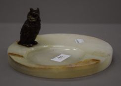 A cold painted bronze model of an owl, on an onyx base. The owl 8 cm high.