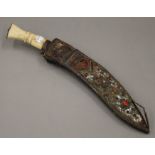 A bone handled kukri in scabbard. 42.5 cm long.