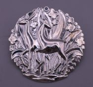 A Danish sterling silver brooch decorated with deer. 4 cm diameter.