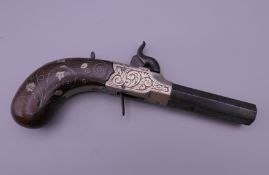 A 19th century white metal inlaid percussion pistol, the barrel inscribed Reilly London. 16 cm long.