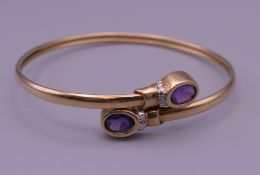 A 9 ct gold bangle set with amethyst. 6 cm diameter. 6.2 grammes total weight.