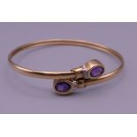 A 9 ct gold bangle set with amethyst. 6 cm diameter. 6.2 grammes total weight.