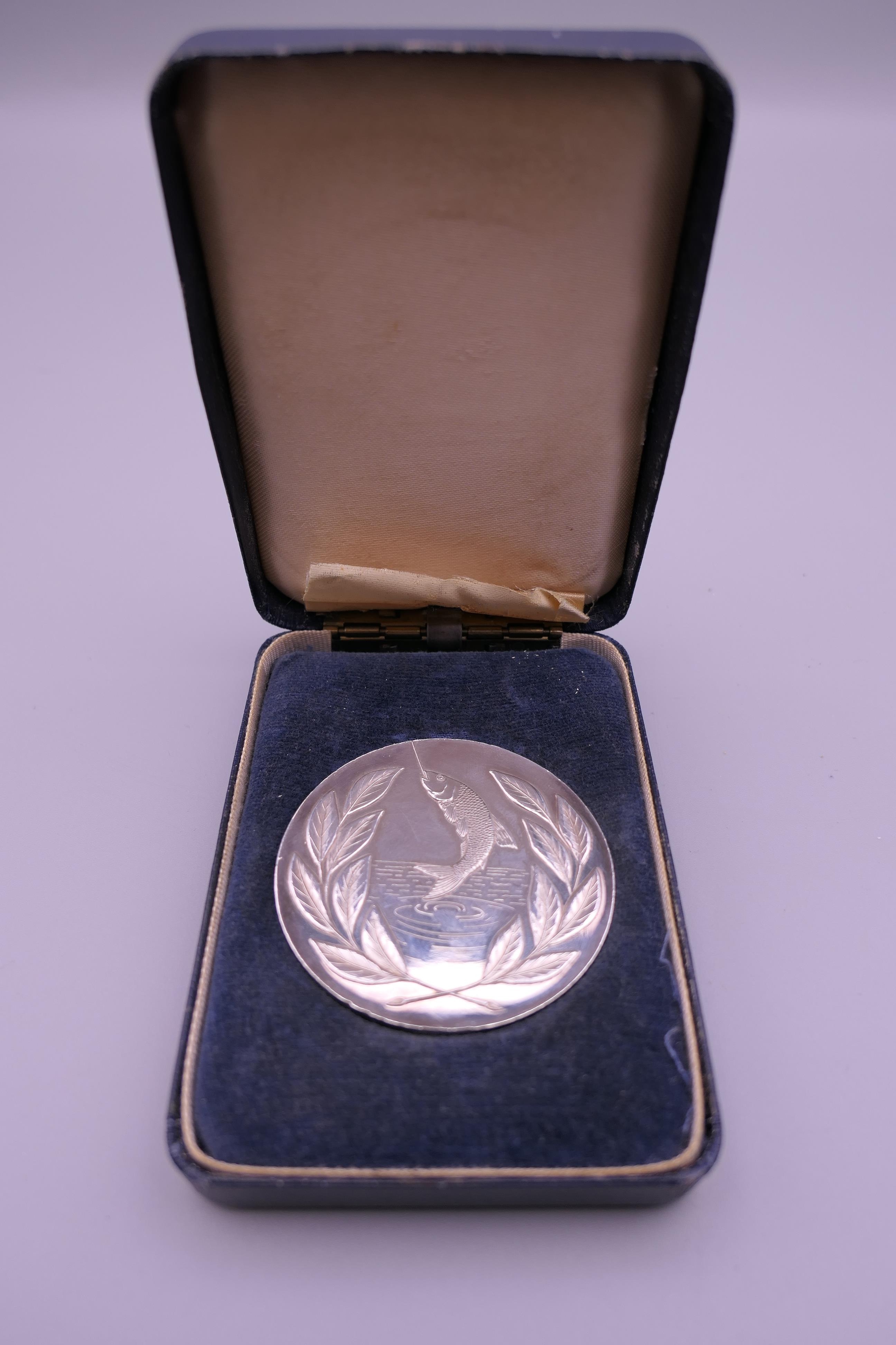 A boxed silver National Federation of Anglers medallion. 5 cm diameter. 57.8 grammes.