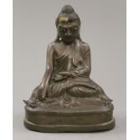 A bronze model of buddha with glass inset eyes. 16 cm high.