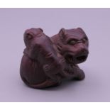 A carved wooden netsuke formed as fo dogs. 4.5 cm long.