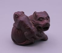 A carved wooden netsuke formed as fo dogs. 4.5 cm long.