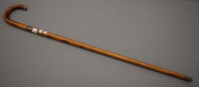 A silver collared Malacca walking stick by Swaine and Brigg. 92 cm long.