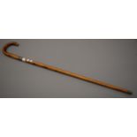 A silver collared Malacca walking stick by Swaine and Brigg. 92 cm long.