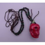 A coral skull pendant. 2.5 cm high.